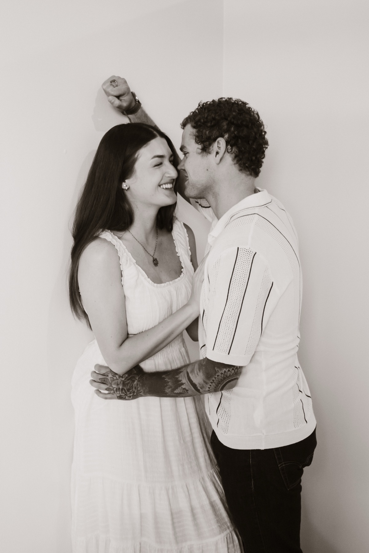 Black and white couple portrait against a clean studio wall.