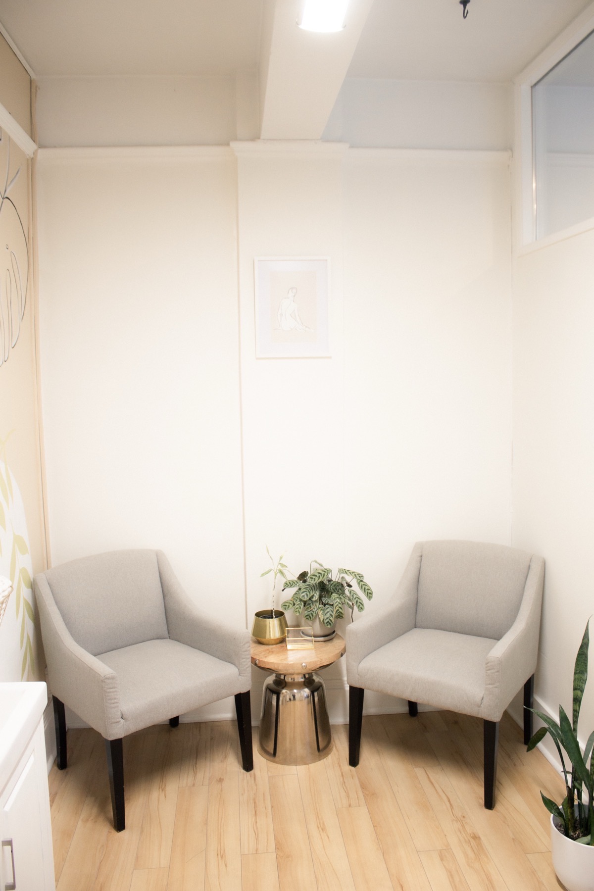 Minimal Studio Rose corner with a wooden stool and soft window light.